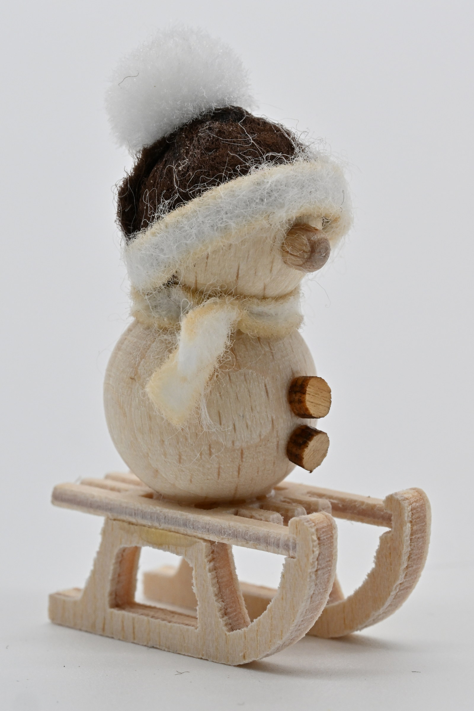 Schneemann natur, auf Schlitten braune Mütze